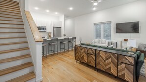 Een moderne keuken met witte kastjes, een ingebouwde magnetron en een roestvrijstalen koelkast.
