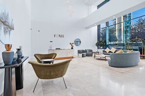 A modern hotel lobby with a reception desk, seating area, and large windows offering city views. - Vogue Downtown Forte Opera District near Burj Khalifa and Dubai Mall (Dubai)