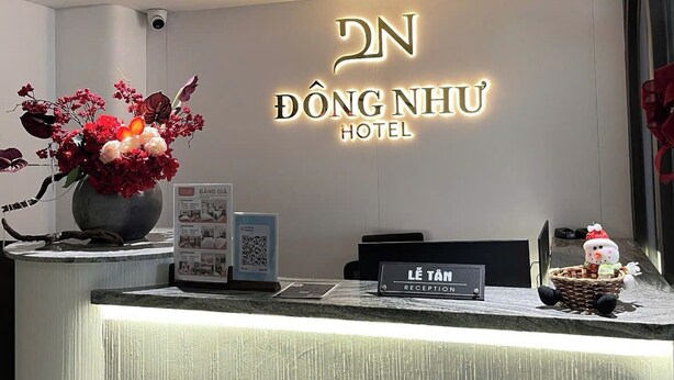 A hotel reception desk with a sign reading "ĐỒNG NHỮ HOTEL" and a "L'ÉTAN RECEPTION" sign. - Dong Nhu 6 Hotel (Ho Chi Minh City)