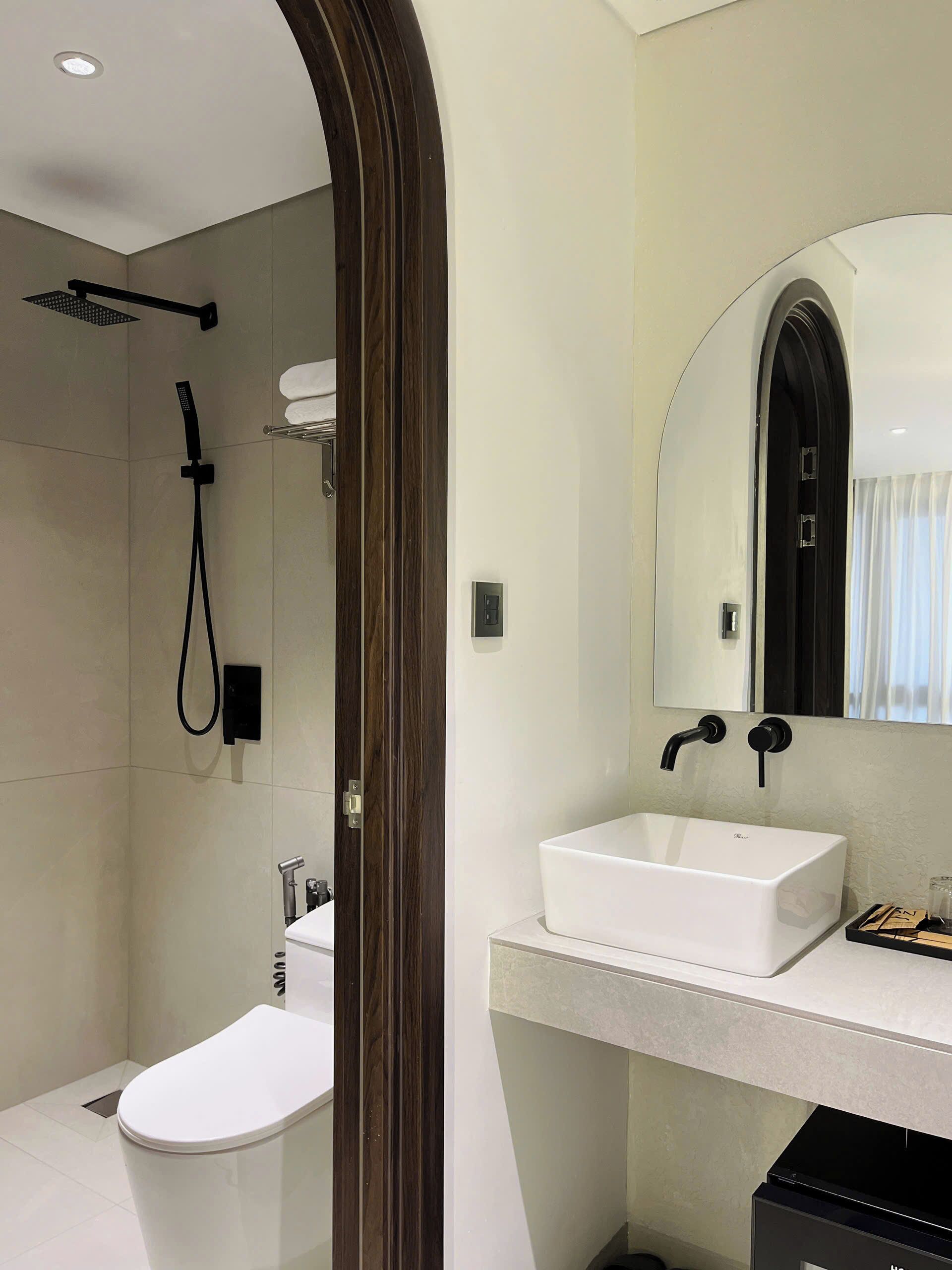 A modern bathroom with a shower, toilet, and sink.