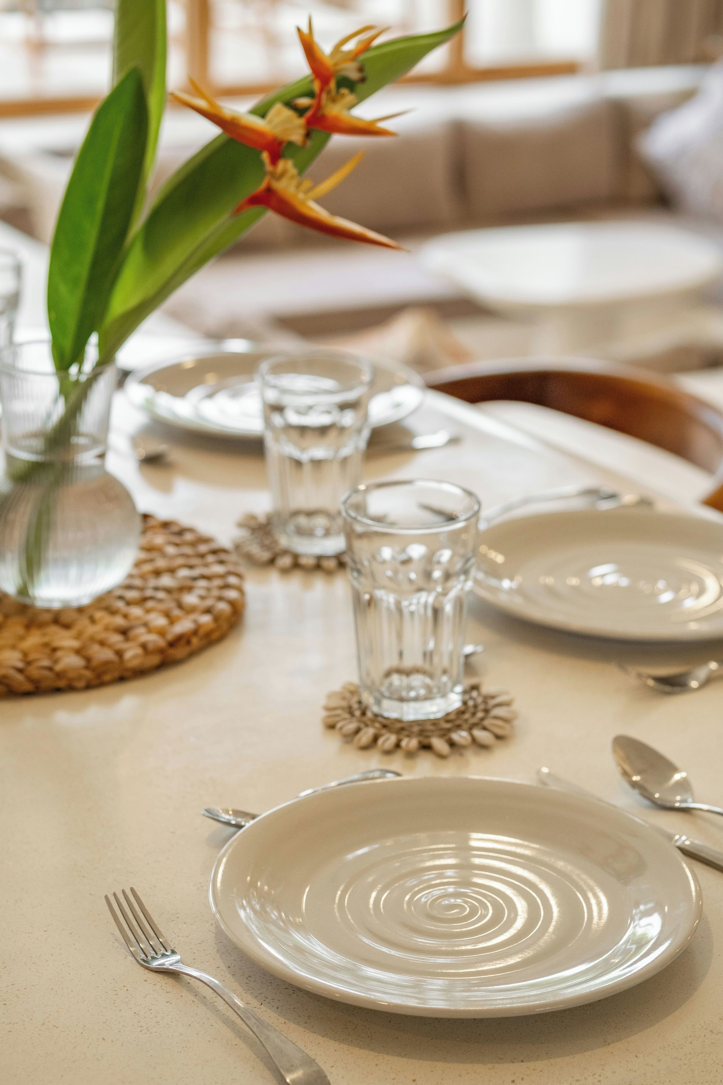 A dining table set with plates, glasses, and cutlery.