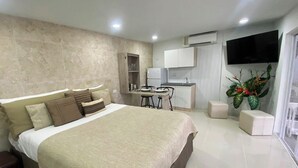 Una habitación de hotel moderna con una cama grande, un escritorio y un televisor.