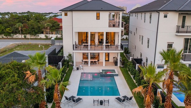 A two-story building with a swimming pool, outdoor seating, and palm trees. - Scarlett's Beach Heaven - Luxury Beach House with Rooftop Views and Pool (Miramar Beach)