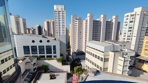 A high-rise building with multiple floors, large windows, and a flat roof. - ACOMODAÇÕES RG APARTAMENTOS SÃO PAULO SP (São Paulo)