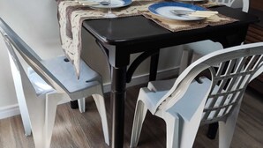 A dining table with four chairs, a black tablecloth, and a patterned table runner. - ACOMODAÇÕES RG APARTAMENTOS SÃO PAULO SP (São Paulo)