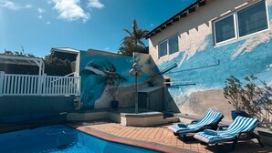 A swimming pool with lounge chairs and a mural wall. - Beachfront apartment with pool & ocean views, 4 mins walk to Beach. Sleeps 7 (Quinns Rocks)