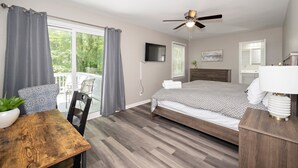 A bedroom with a bed, a desk, a chair, a ceiling fan, a TV, and a window with curtains. - Charming Cary Home~Centrally Located~Comfortable beds (Cary)