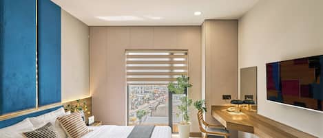A modern bedroom with a bed, bedside table, and a view of the city through a window.