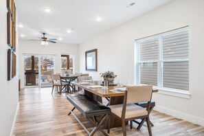 Un comedor amplio con una larga mesa de madera, sillas acolchadas y un banco.