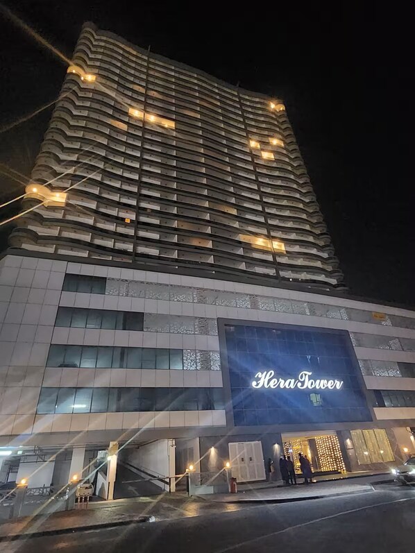 Un hotel de gran altura con un llamativo letrero 'Heritage Tower', varios pisos y un diseño arquitectónico moderno.