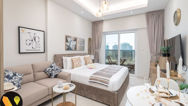 A modern bedroom with a bed, sofa, and dining area.