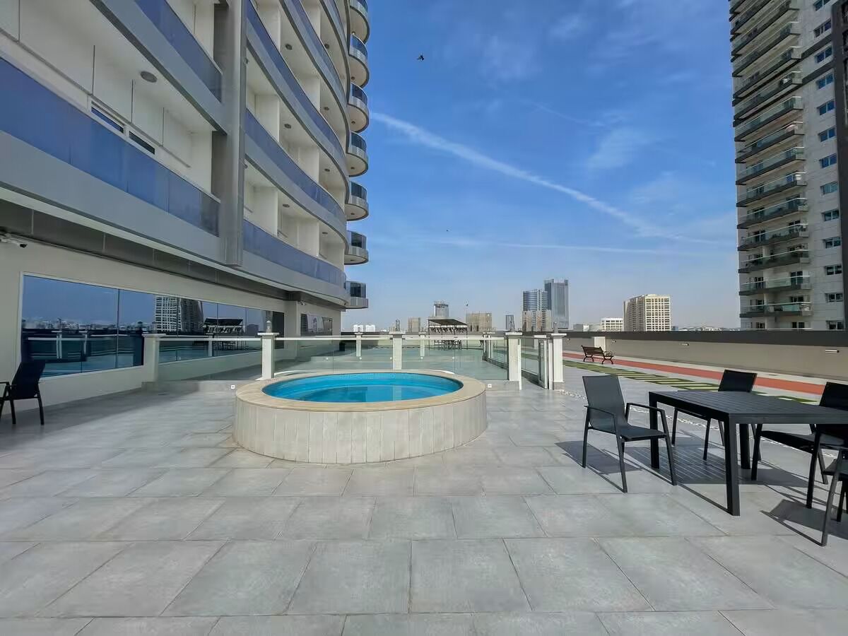 Une terrasse sur le toit avec une piscine, des sièges extérieurs et une vue sur la ville.
