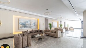 A modern living room with a sectional sofa, a coffee table, and artwork on the walls.