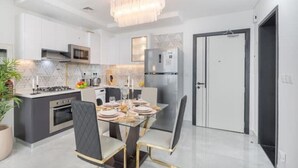 Una cocina moderna con comedor, electrodomésticos de acero inoxidable y una araña.