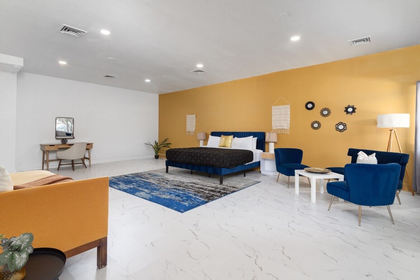A modern bedroom with a bed, bedside tables, a desk, and a chair.