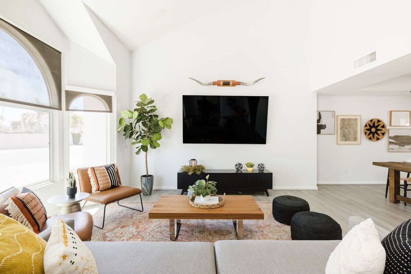 A modern living room with a large TV, a coffee table, and a sofa.