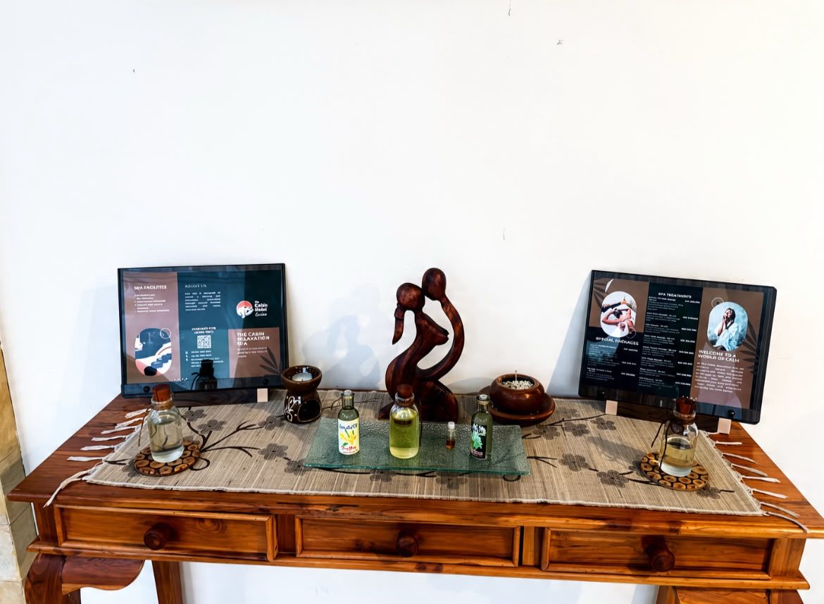Een houten bureau met twee schermen, een decoratief paardbeeldje en diverse kleine flesjes en potjes.