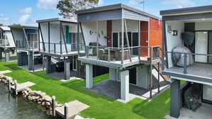 A modern waterfront property with multiple elevated structures featuring balconies and outdoor seating areas. - Cabin 60 - Lake Conjola (Lake Conjola)
