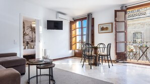 Un salon moderne comprenant un canapé, une table basse et un coin repas avec des chaises et une table.