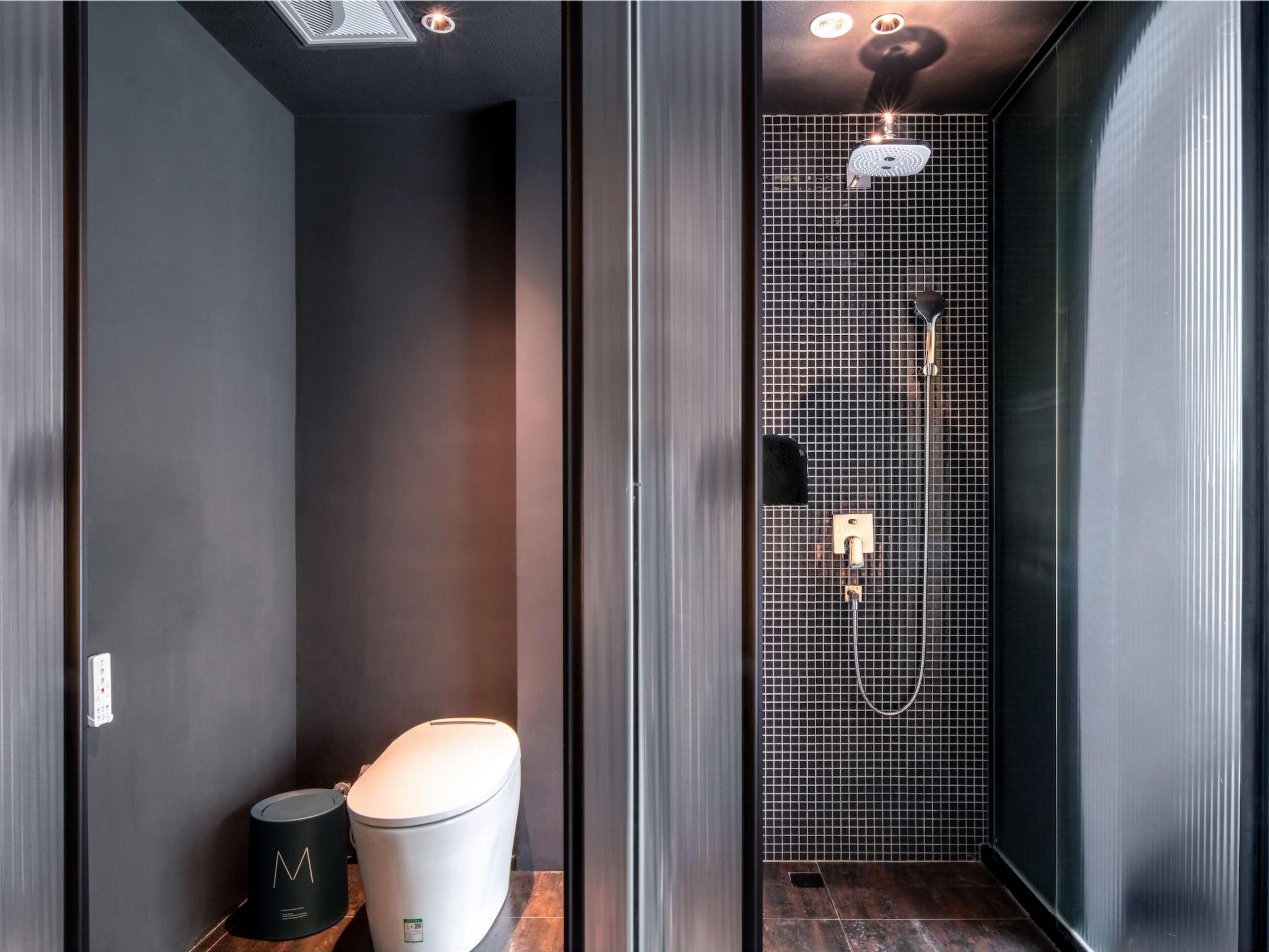 A modern bathroom with a toilet, bidet, and shower.
