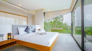 A modern bedroom with a large bed, a bedside table, and a view of greenery through large windows.