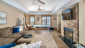 A living room with a pool table, fireplace, and large windows. - Large, Ski-in/Ski-Out, Hot Tub, Wet Bar, Sleeps 16 (Beech Mountain)