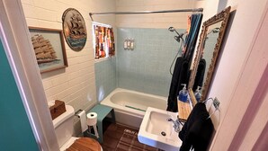 A compact bathroom with a bathtub, toilet, sink, and a mirror. - Vintage Motel Room in sunny Tucson with WiFi, AC "Tequila Sunrise" (Tucson)