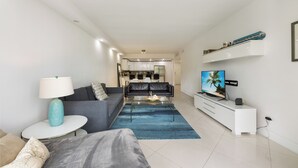 En moderne stue med sofa, sofabord og fjernsyn.