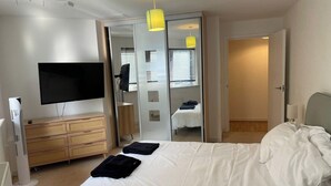 A bedroom with a bed, a TV, a dresser, and a mirror. - 1Bedroom - Sleeps 2 - Terrace, Bbq, Near Transport (London)