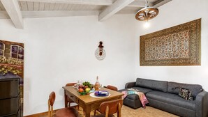 Un comedor con mesa de madera, sillas y un sofá gris.