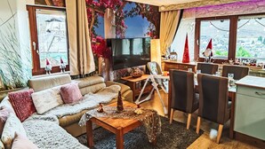 A cozy living room with a sofa, coffee table, and a TV. There's a dining area with chairs and a table. - Ruhrtalblick by Interhome (Winterberg)
