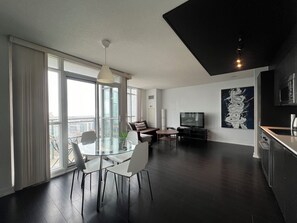 Apartamento superior, 2 habitaciones | Zona de estar | Smart TV de 65 pulgadas con canales digitales