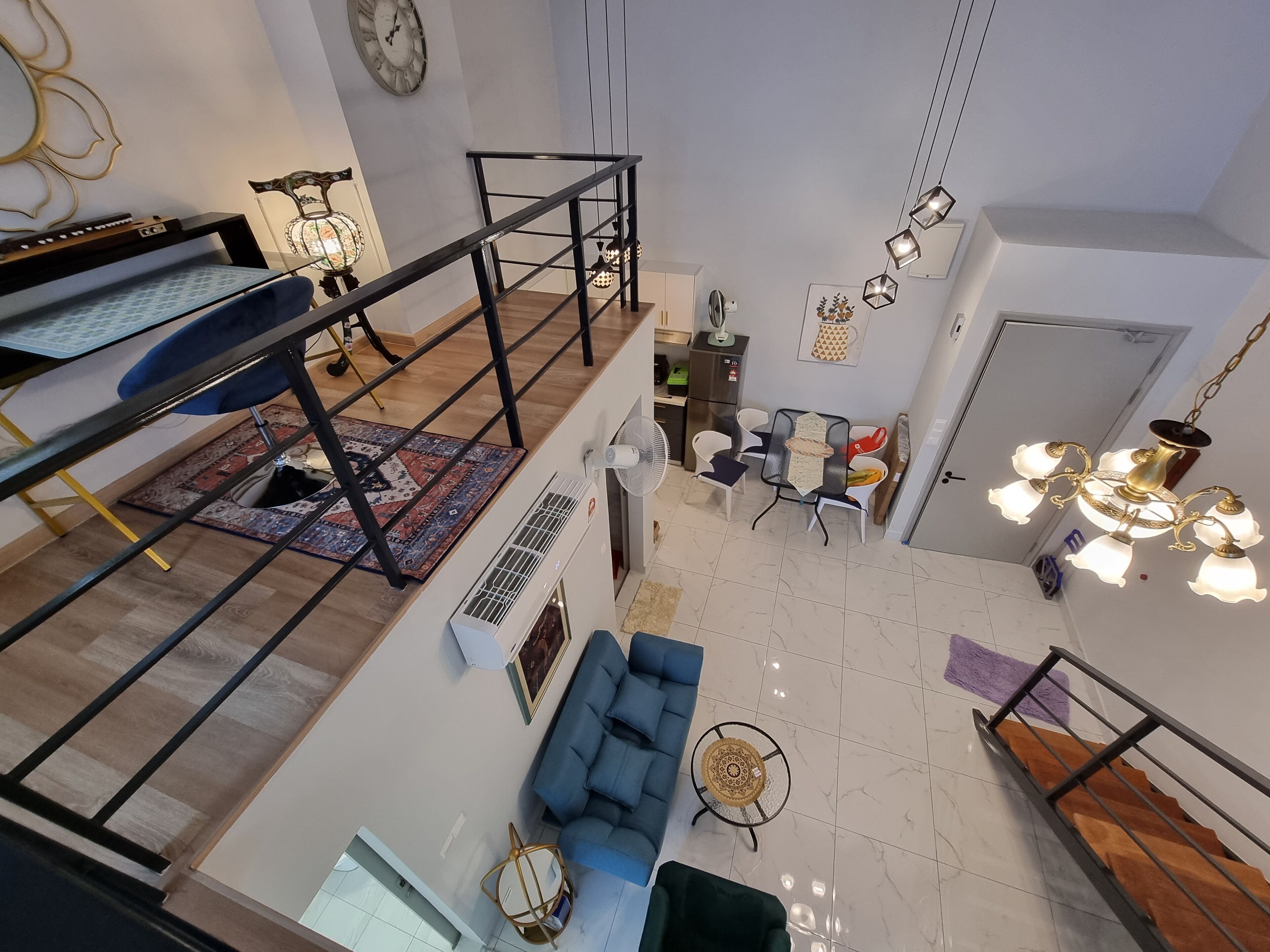 Ein mehrstöckiger Wohnbereich mit Treppe, Essbereich und Sitzgelegenheit.