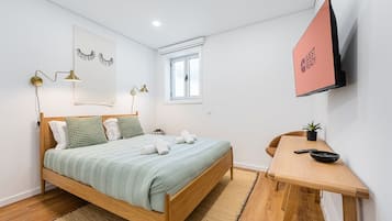 Tabla de planchar con plancha, internet y ropa de cama
