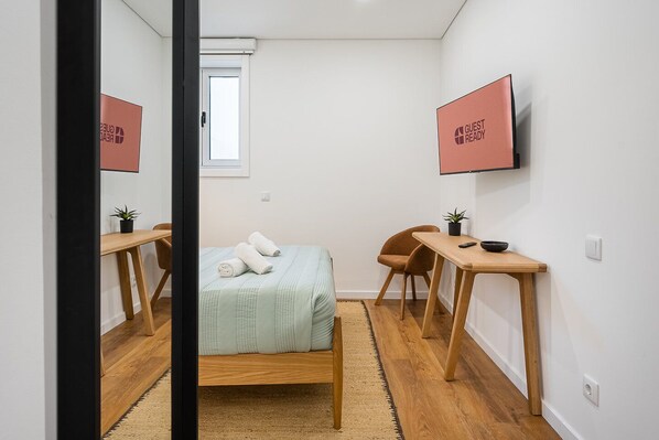 Tabla de planchar con plancha, acceso a internet y ropa de cama