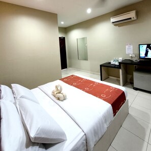 A hotel room with a bed, a desk, a TV, and an air conditioning unit. - Hotel O Guesthouse Dseribong (Kota Bharu)