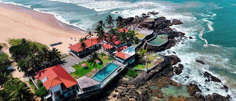Accommodatie ligt op het strand, wit zand, ligstoelen, parasols