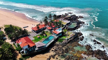 Na praia, areia branca, espreguiçadeiras, guarda-sóis