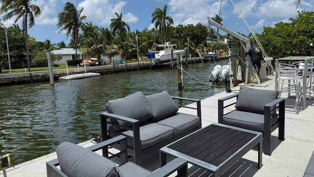 A marina with docked boats, a water feature, and outdoor seating.