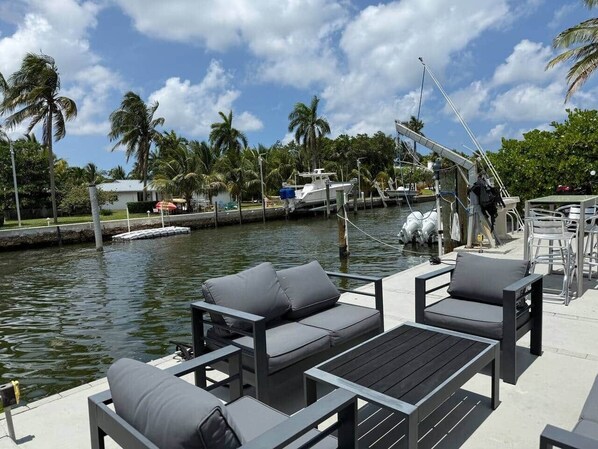 A marina with docked boats, a water feature, and outdoor seating.