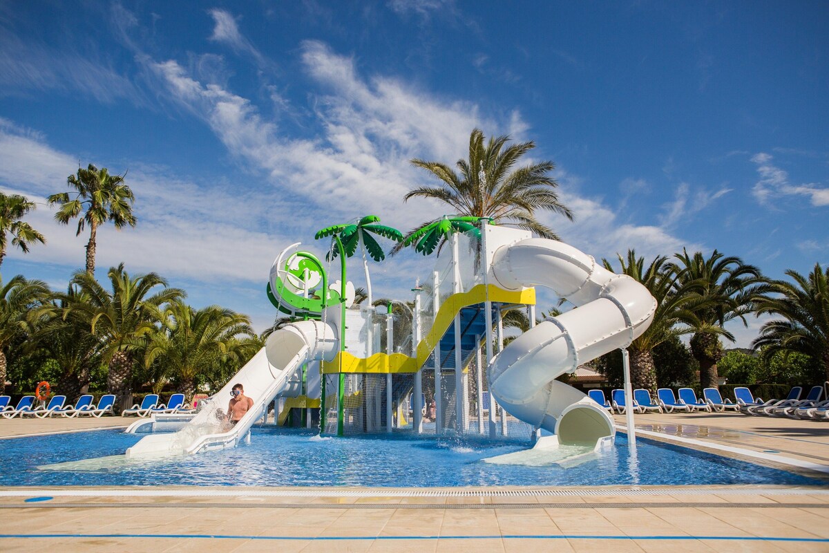 A water park with slides and palm trees.