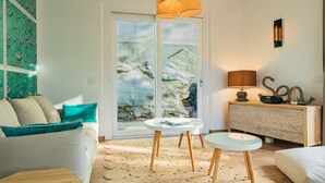 A modern living room with a sofa, a coffee table, and a side table with a lamp. - Appartamento Mare di Spartaia (Marciana)