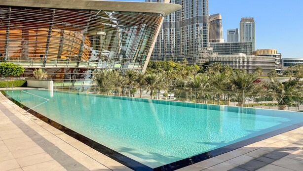 A modern outdoor swimming pool with a clear view of tall buildings in the background.