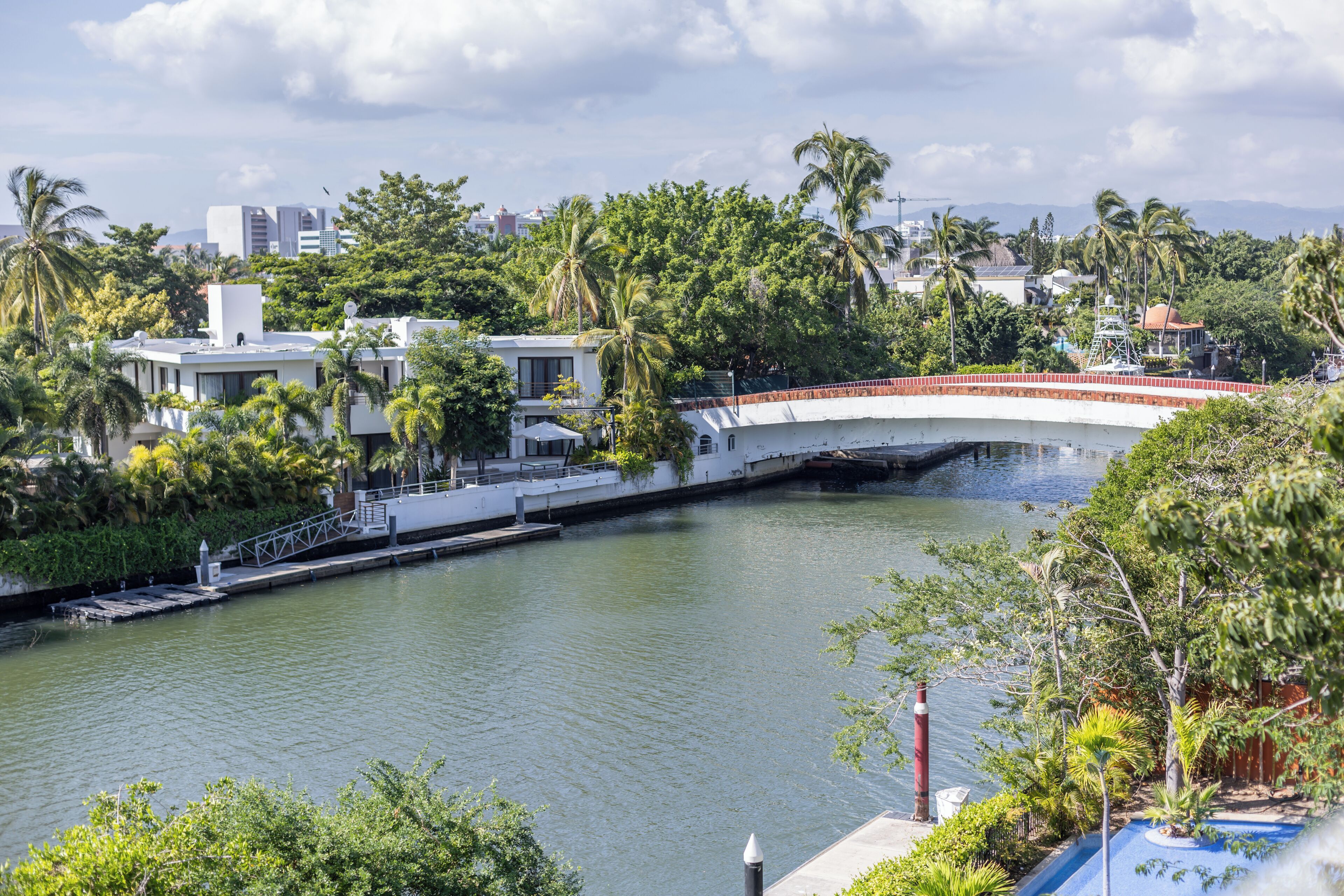 Un río con un puente, rodeado de vegetación y edificios.