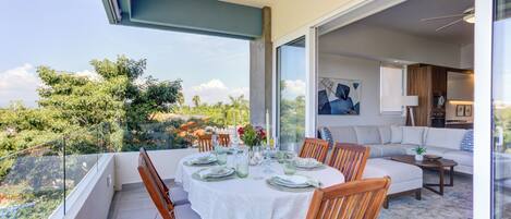 A dining area with a table set for six, overlooking a lush garden.