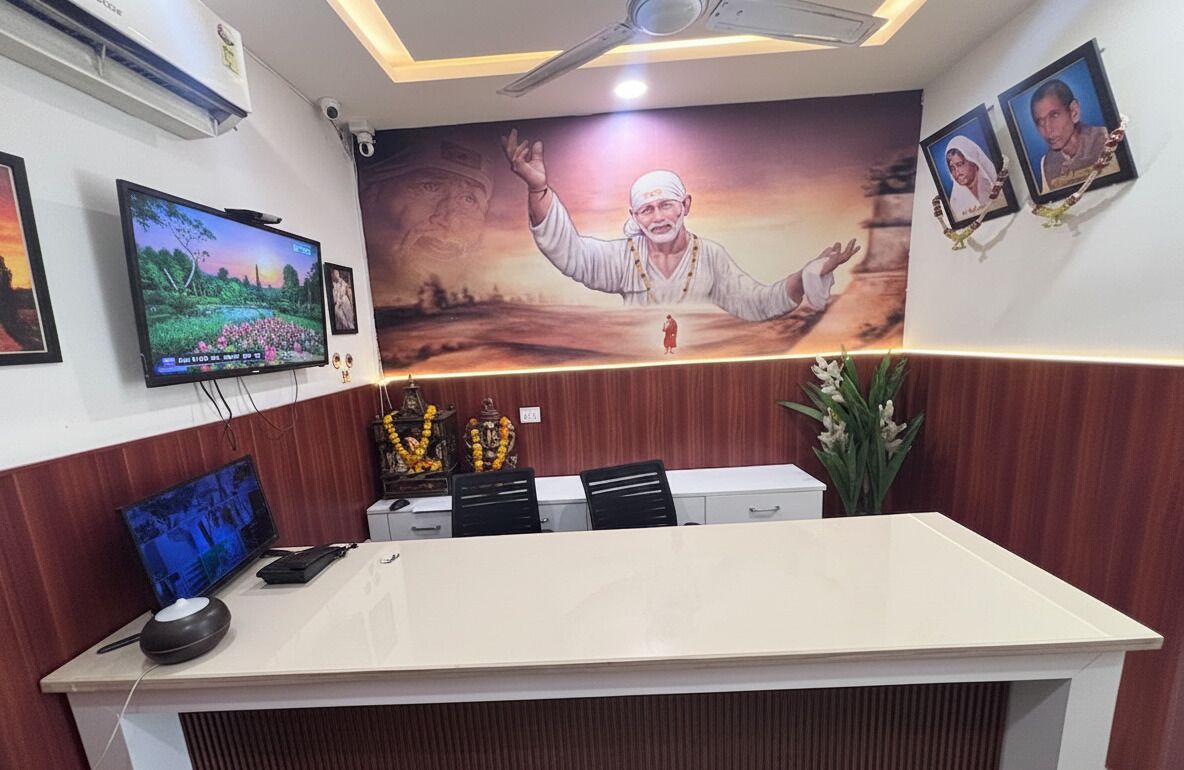 Un mostrador de recepción con una televisión, un mural grande y cuadros en la pared.