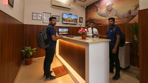 A reception desk with a wooden panel design, a potted plant, and a framed picture on the wall. - Hotel Shri Sai Deluxe - 1 Min from Adarsh Nagar Metro | Couple, Business, and Family Friendly (New Delhi)