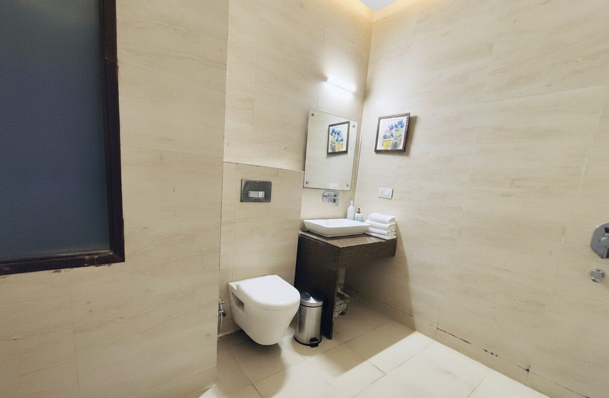 A small, modern bathroom with a toilet, sink, and mirror.