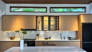 Une cuisine moderne avec des meubles en bois, un plan de travail en marbre et un îlot central.