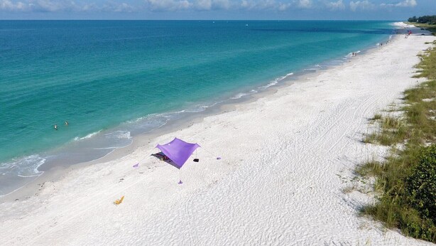 A beach with a tent and a clear view of the ocean.